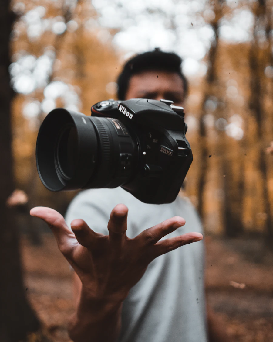 Photographer tossing a camera in an autumn forest