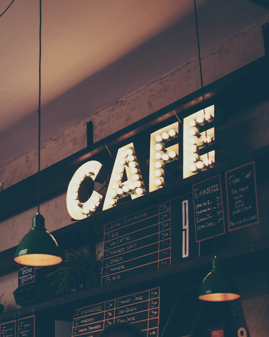 Warmly lit café with an illuminated CAFE sign above the menu boards