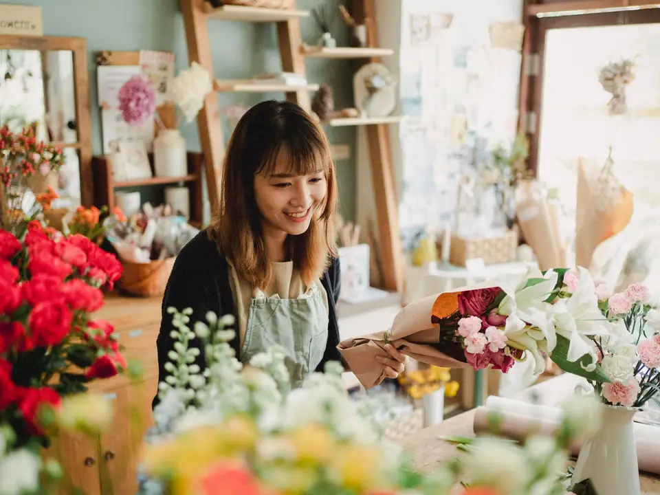 Florist business owner arranging flowers in her shop