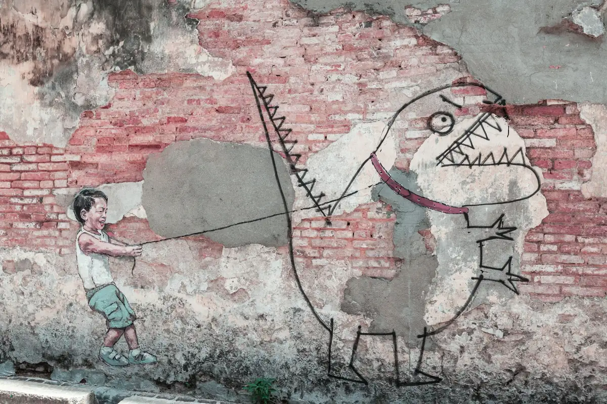 George Town street art mural of a boy walking a dinosaur on a brick wall